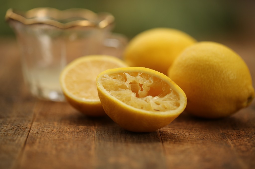 sliced, squeezed lemons next to glass pitcher