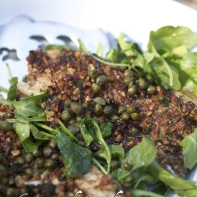 Herb and Pecan Crusted Trout arranged on plate with greens and sauce