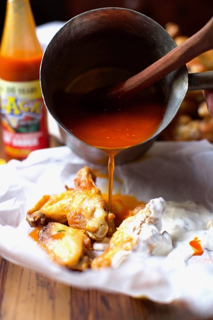 Drenching chicken wings with hot sauce