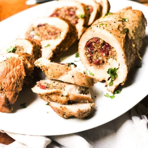 Turkey Breast Stuffed with Sausage and Cranberry on white plate