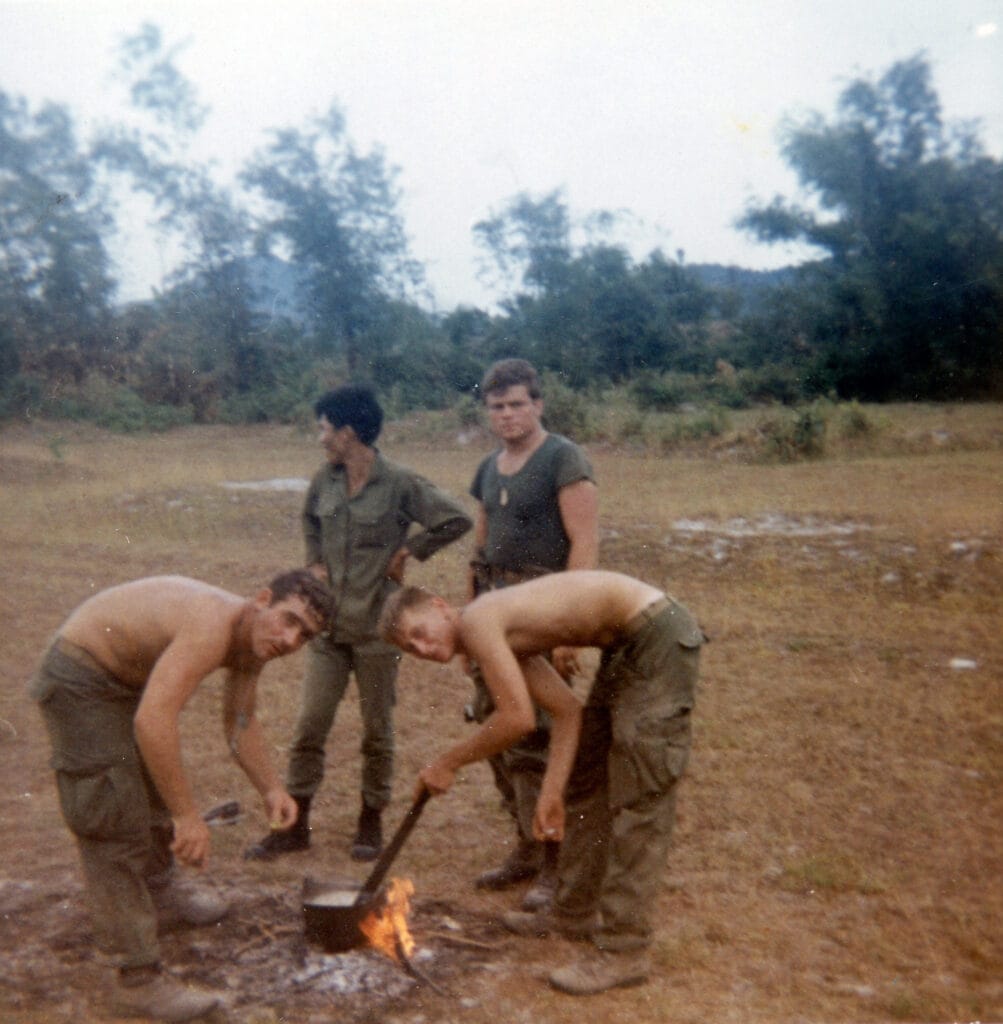Soldiers in Vietnam War cooking in helmets