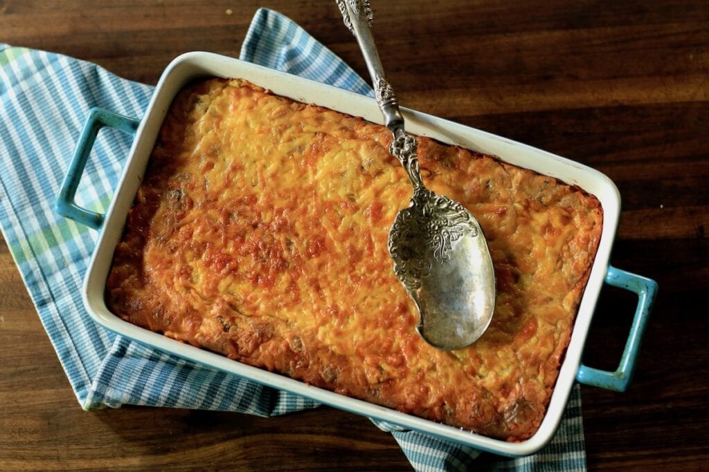 grits casserole with silver spoon on top