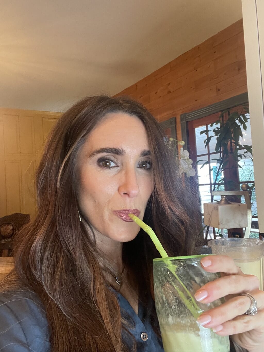 Stacy Lyn drinking a homemade orange julius smoothie with a straw